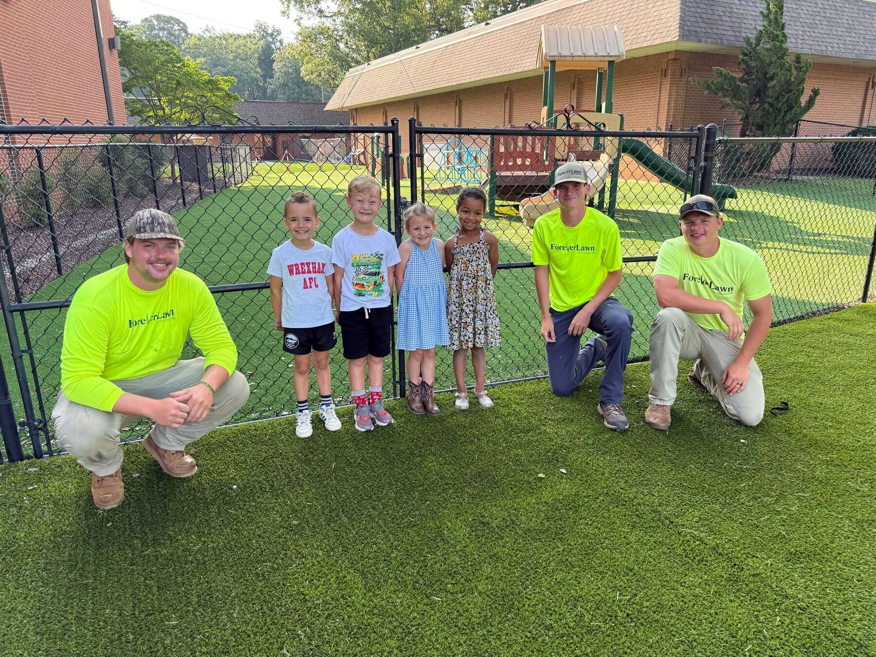 Wesleyan preschool students with the team that installed the new playground turf
